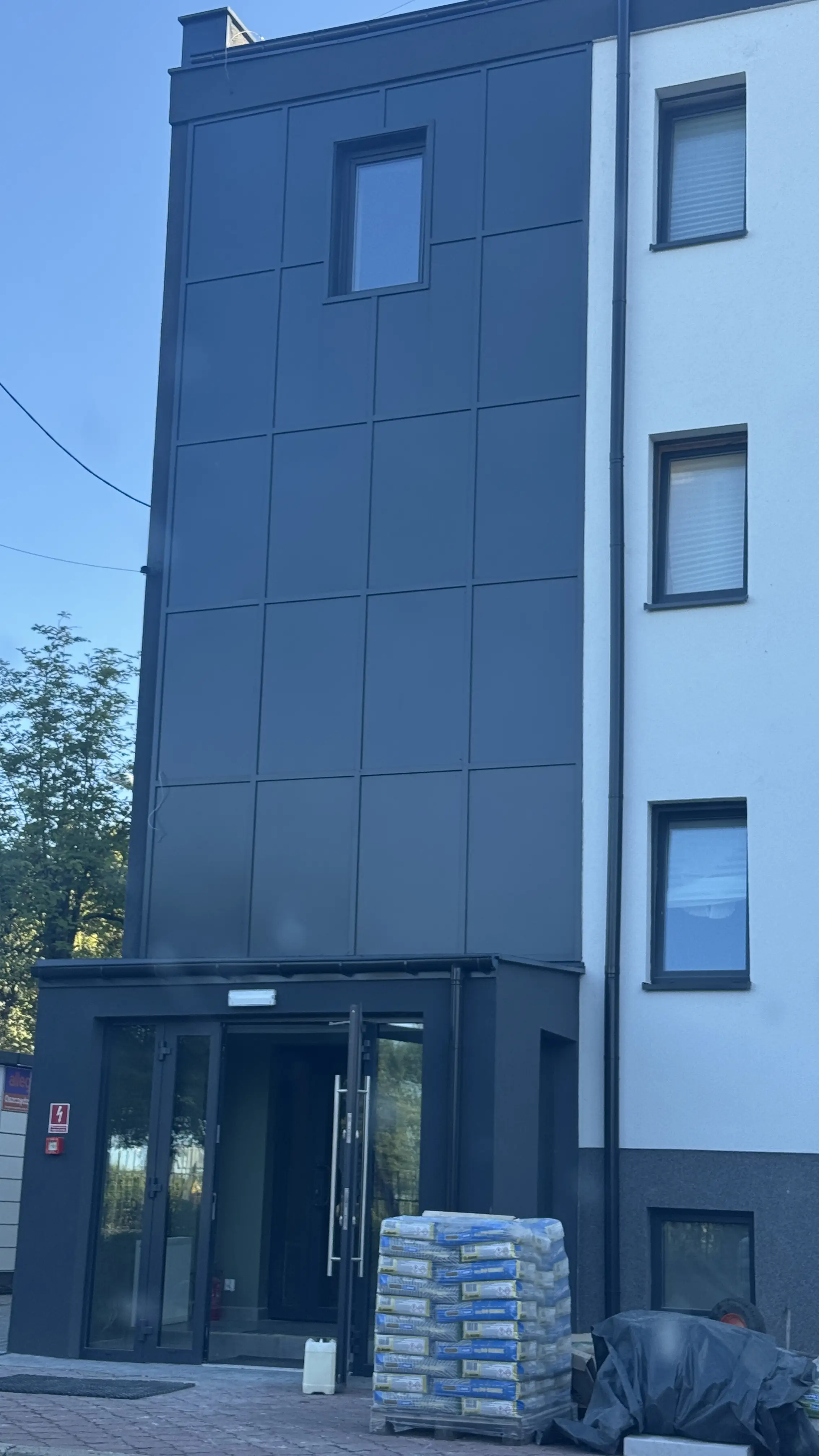 Czarna fasada aluminiowa kompozytowa z wejściem w budynku usługowym — Płock