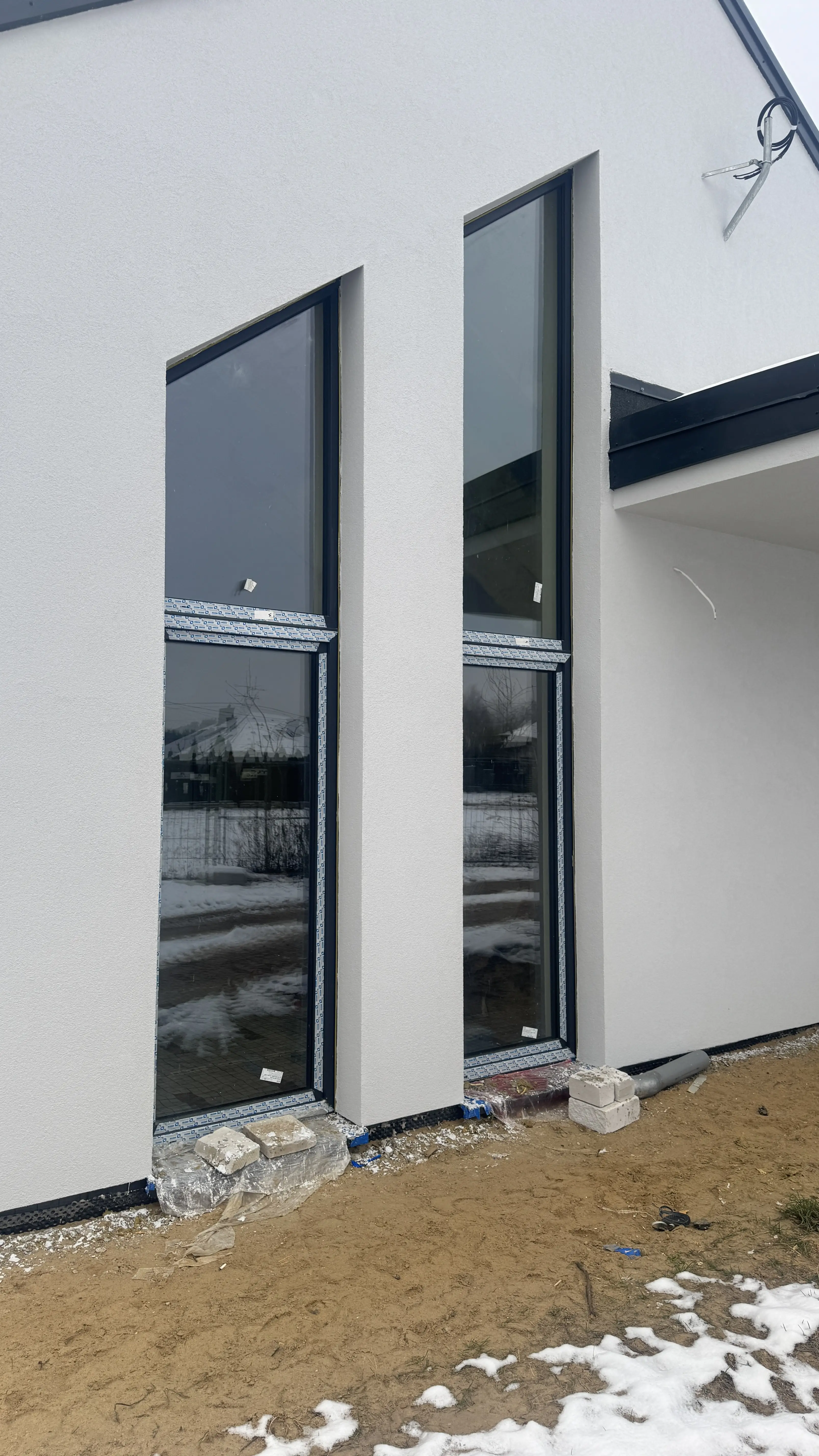 Wysokie okna aluminiowe antracytowe w nowoczesnym domu jednorodzinnym — realizacja Płock